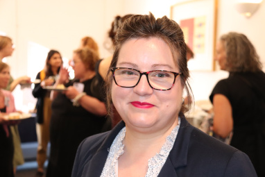 A woman with glasses smiling directly into the camera