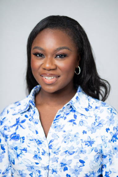 A woman smiling, wearing a blue and white top