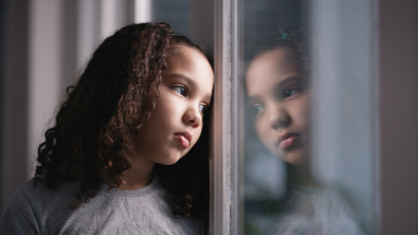 Young girl looks pensively out of the window