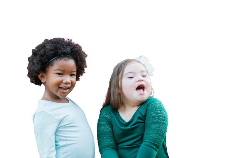 Black girl with blue top next to girl with Down's wearing green top and white bow in hair