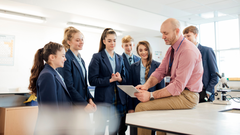 Teacher sitting talking to students around them