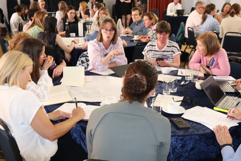 A group of adults sat around tables discussing a vision for Early Years at the NCB Summit