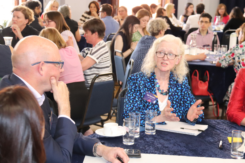 A group of adults sat around tables discussing a vision for Early Years at the NCB Summit