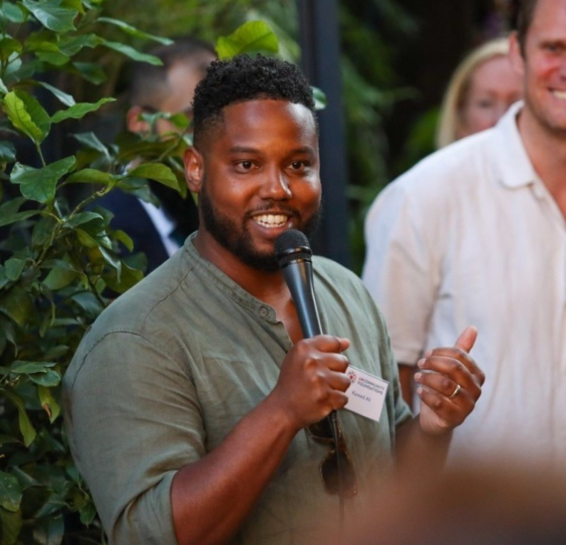 Kaveed holding a microphone and giving a speech