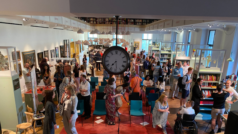 A wide view of the Welcome Trust reading room with packed with audience members