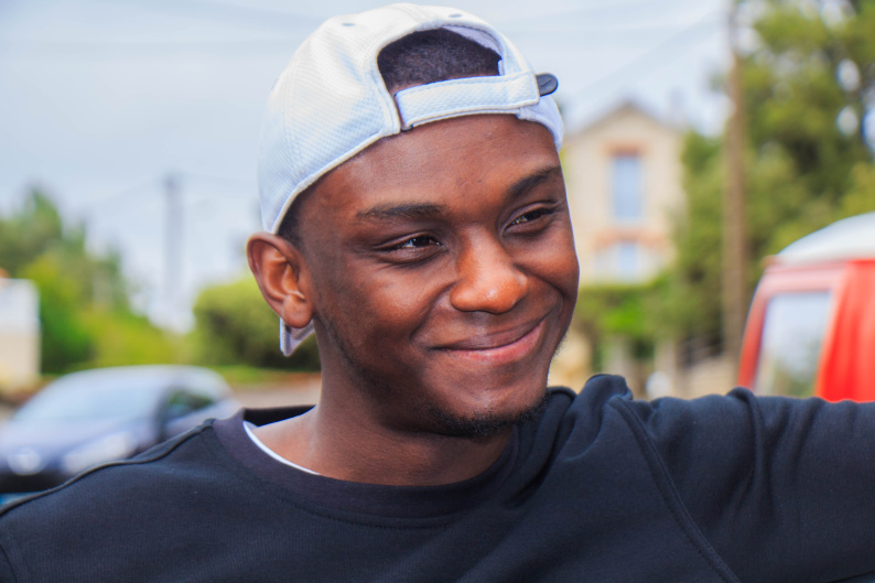 A young person smiles as he listens.