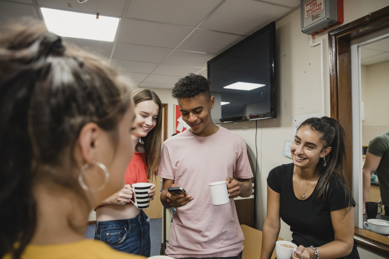 A group of young people talking and smiling together