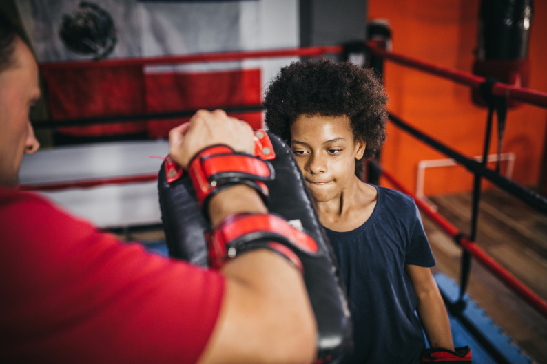 Young person with adult in boxing ring