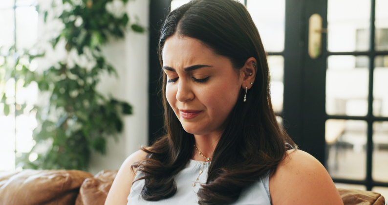 Woman with eyes closed looking sad